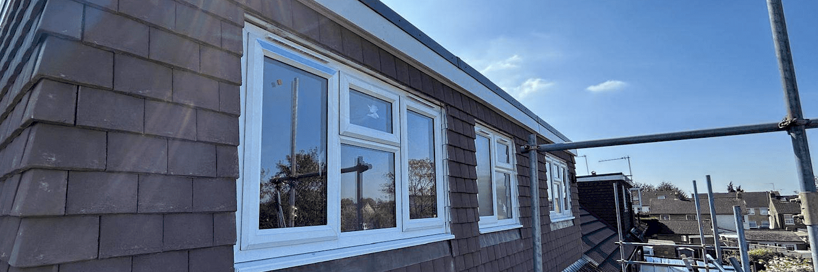 Bright and airy dormer loft conversion under a clear blue sky.