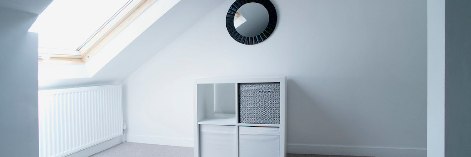 Bright and airy loft conversion featuring a light Velux window and natural pine finish.