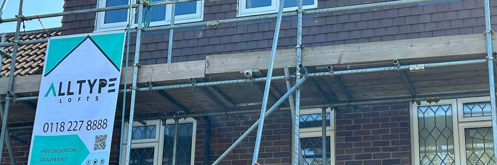 Exterior view of a dormer loft conversion still surrounded by scaffolding, showcasing the ongoing transformation and structural details. Ideal for loft conversion progress and construction inspiration.