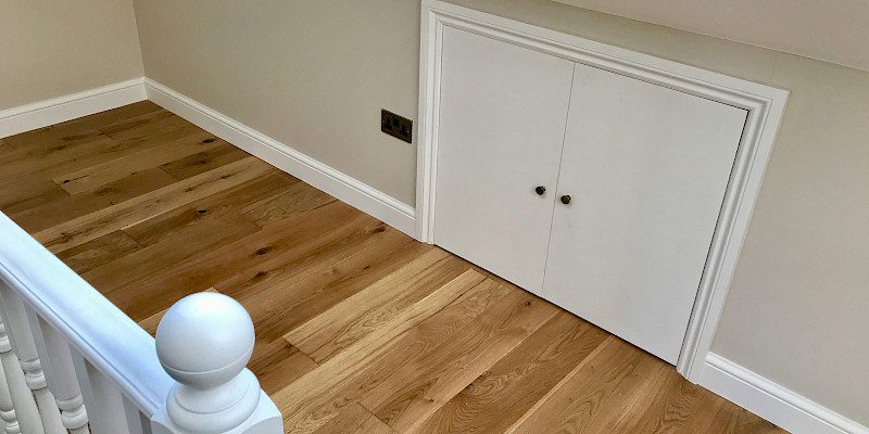 Elegant wooden balustrade and floor in a stylish loft space, featuring a wooden access panel for a seamless, natural look. Perfect for interior design and loft conversion inspiration.