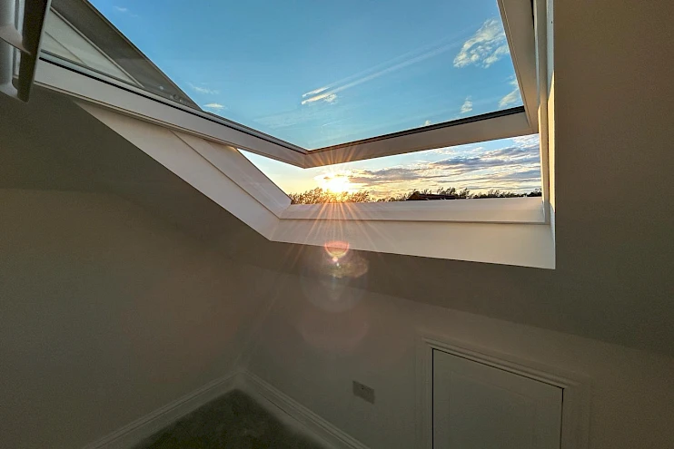 Stunning view through Velux windows capturing a vibrant sunset sky.